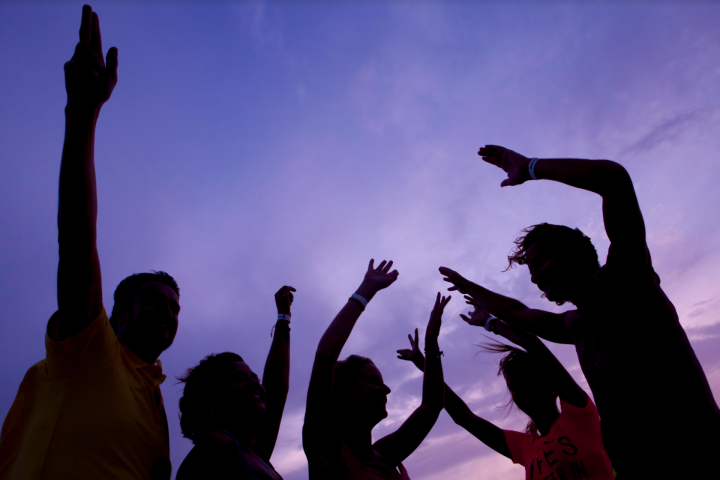 a group of people standing in front of a cloudy sky